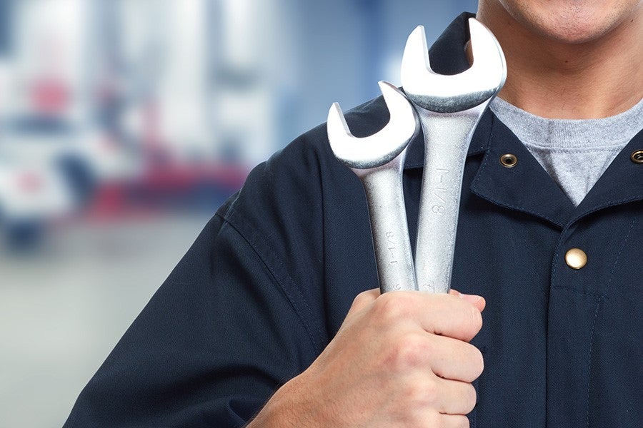mechanic holding up wrenches